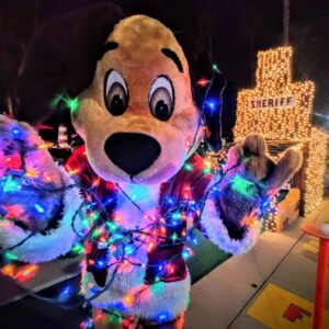 Fiesta Village mascot holding Christmas lights